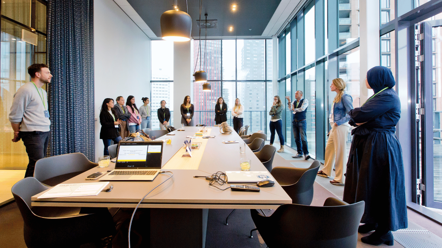 je ziet deelnemers van een workshop aan een grote tafel staan